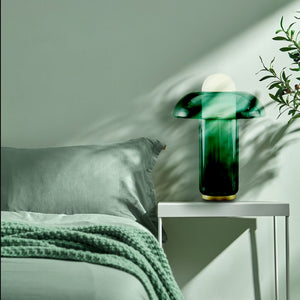 Lampe champignon en verre verte dans une chambre vert d'eau