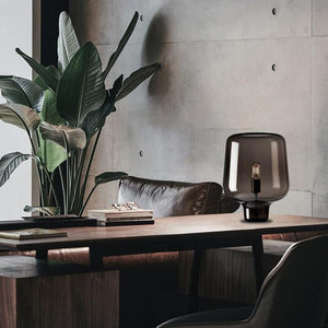 Lampe design en verre noir sur un bureau en bois