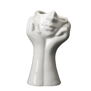 Vase en forme de main qui tiennent un visage 